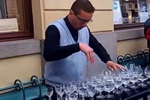 Уличный музыкант исполняет классику на винных бокалах